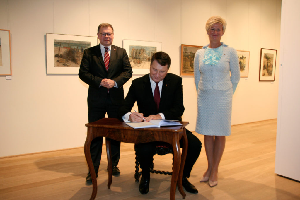 Der Lettische Staatspräsident beim Eintrag in das Besucherbuch des Museums