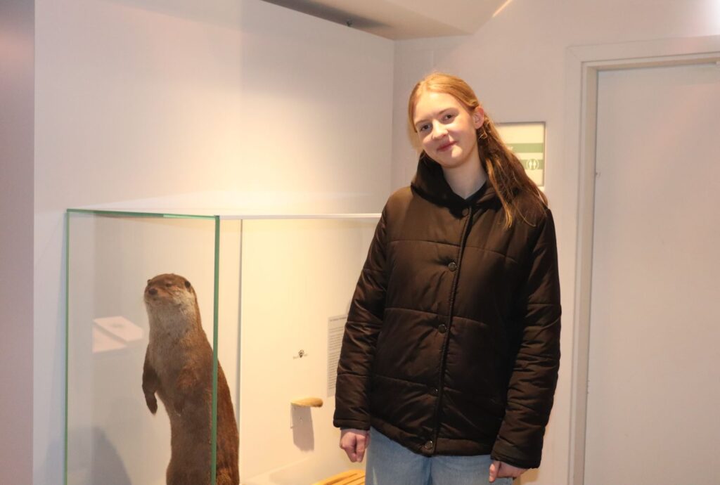 Die Praktikantin Clara vor einem Otter, der symbolisch für ihr Lieblingsobjekt und unseren Kinderpfad im Museum steht